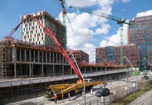 Betonowóz z pompą na placu budowy podczas wylewania fundamentów domu jednorodzinnego