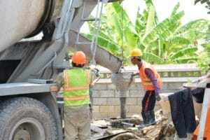 ekipa budowlana wylewająca beton na szalunki stropowe z wykorzystaniem pompy do betonu