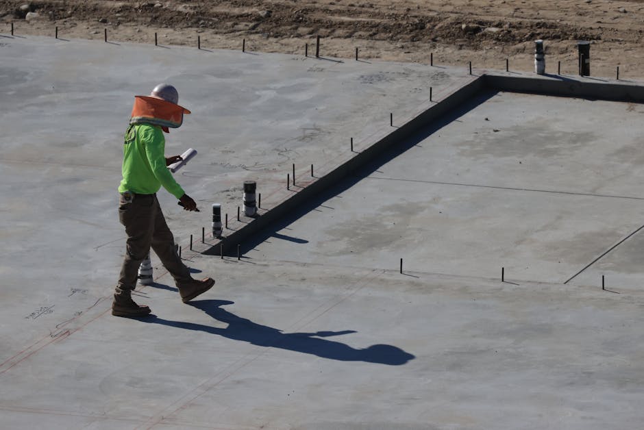 Pracownik budowlany sprawdzający parametry wylewanego betonu fundamentowego