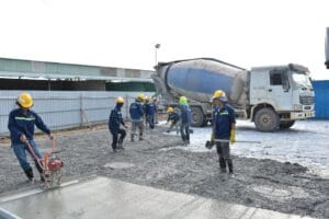 Profesjonalna ekipa wylewająca beton na posadzkę w nowoczesnym domu