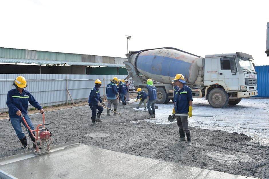 Profesjonalna ekipa wylewająca beton na posadzkę w nowoczesnym domu